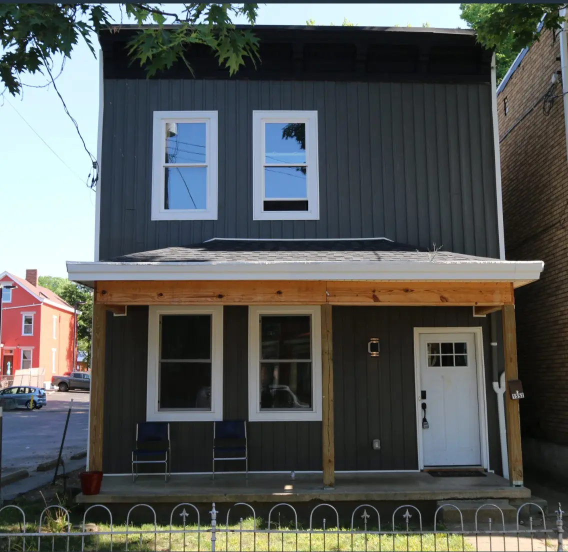 Dark gray board-and-batten Dream Chasers home with a wide covered porch.