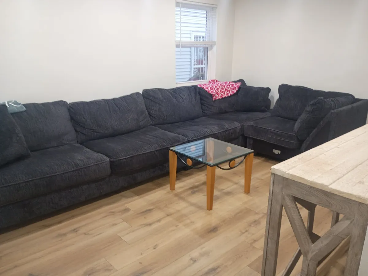 Common room in one of our homes with a large sectional couch.